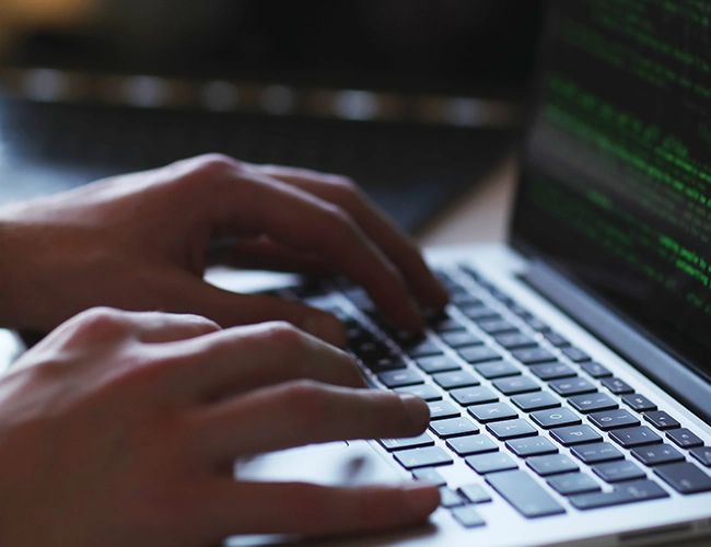 Close-up shot of person typing on laptop